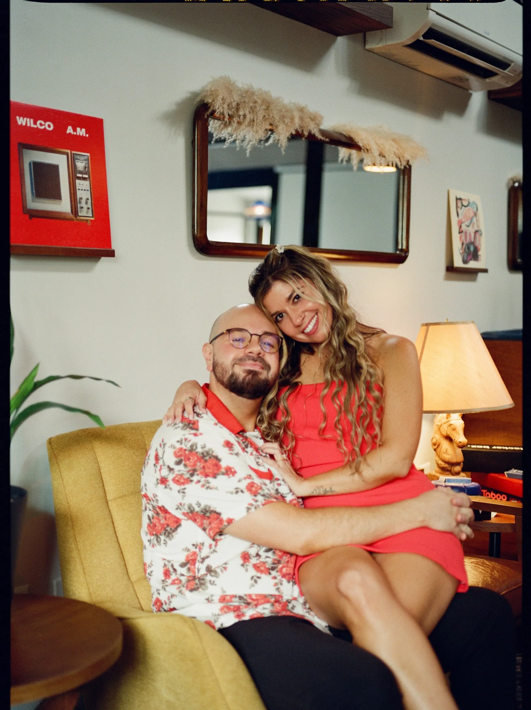 Nicole sitting on Ian's lap in a mustard armchair