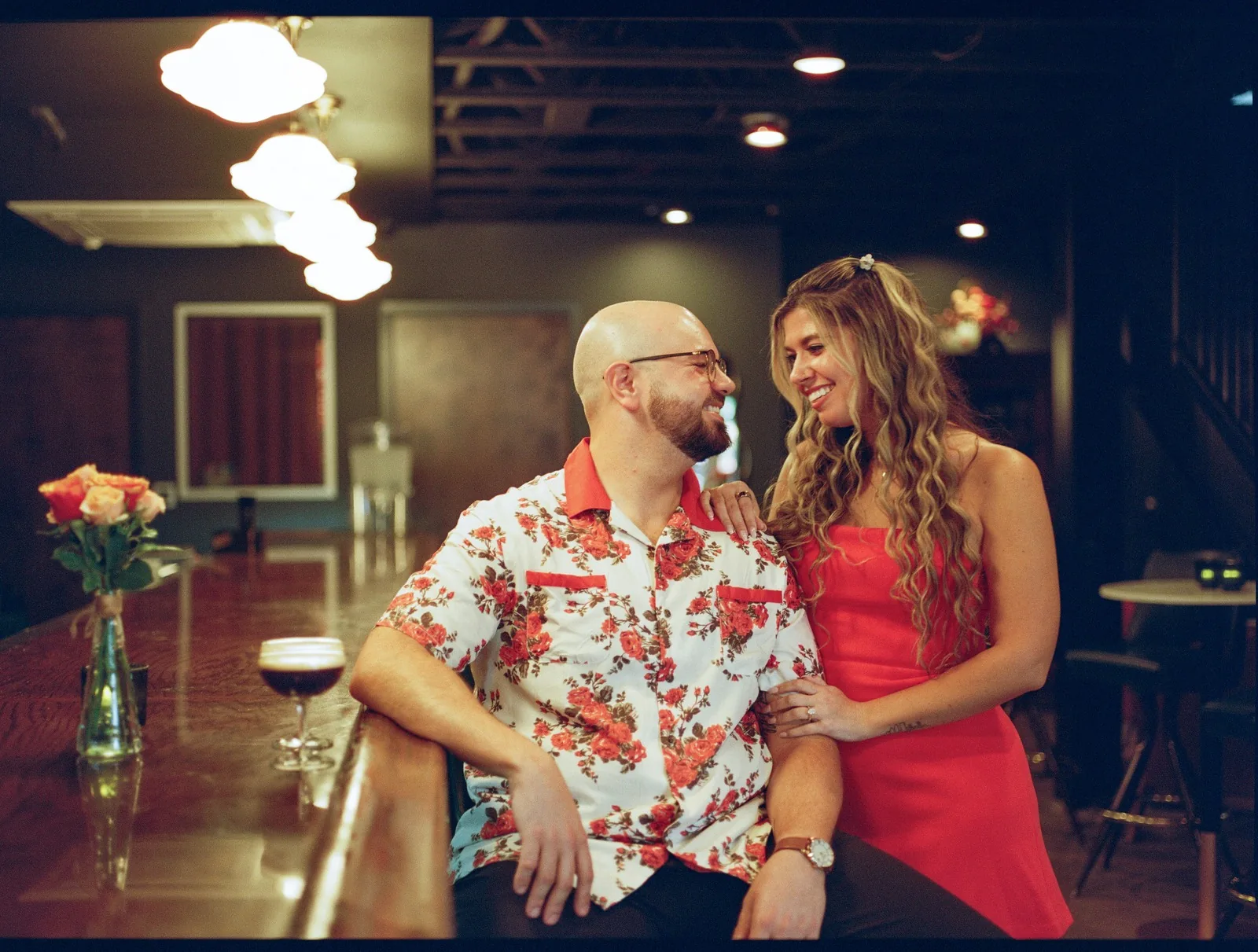 Nicole and Ian at a bar counter under warm lights