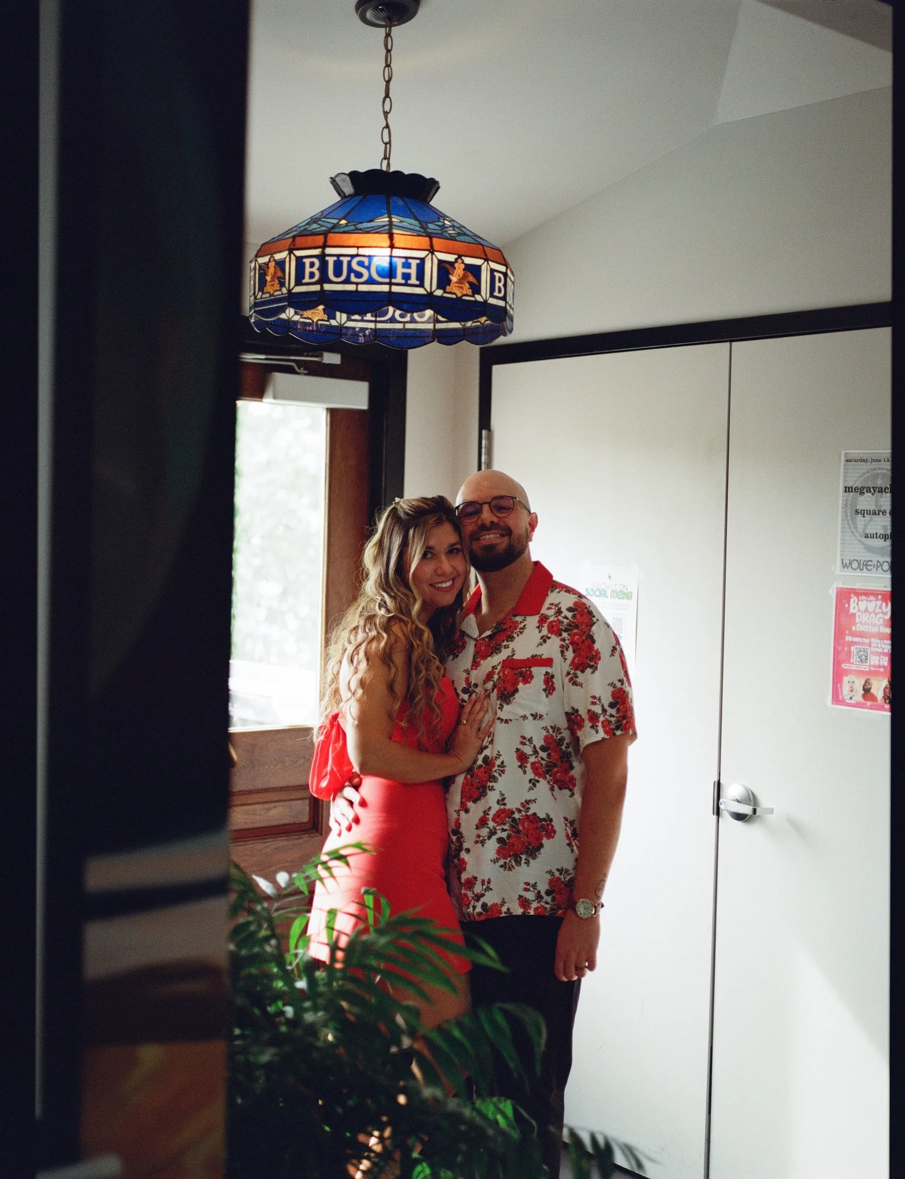 Nicole and Ian by a doorway under a stained-glass lamp