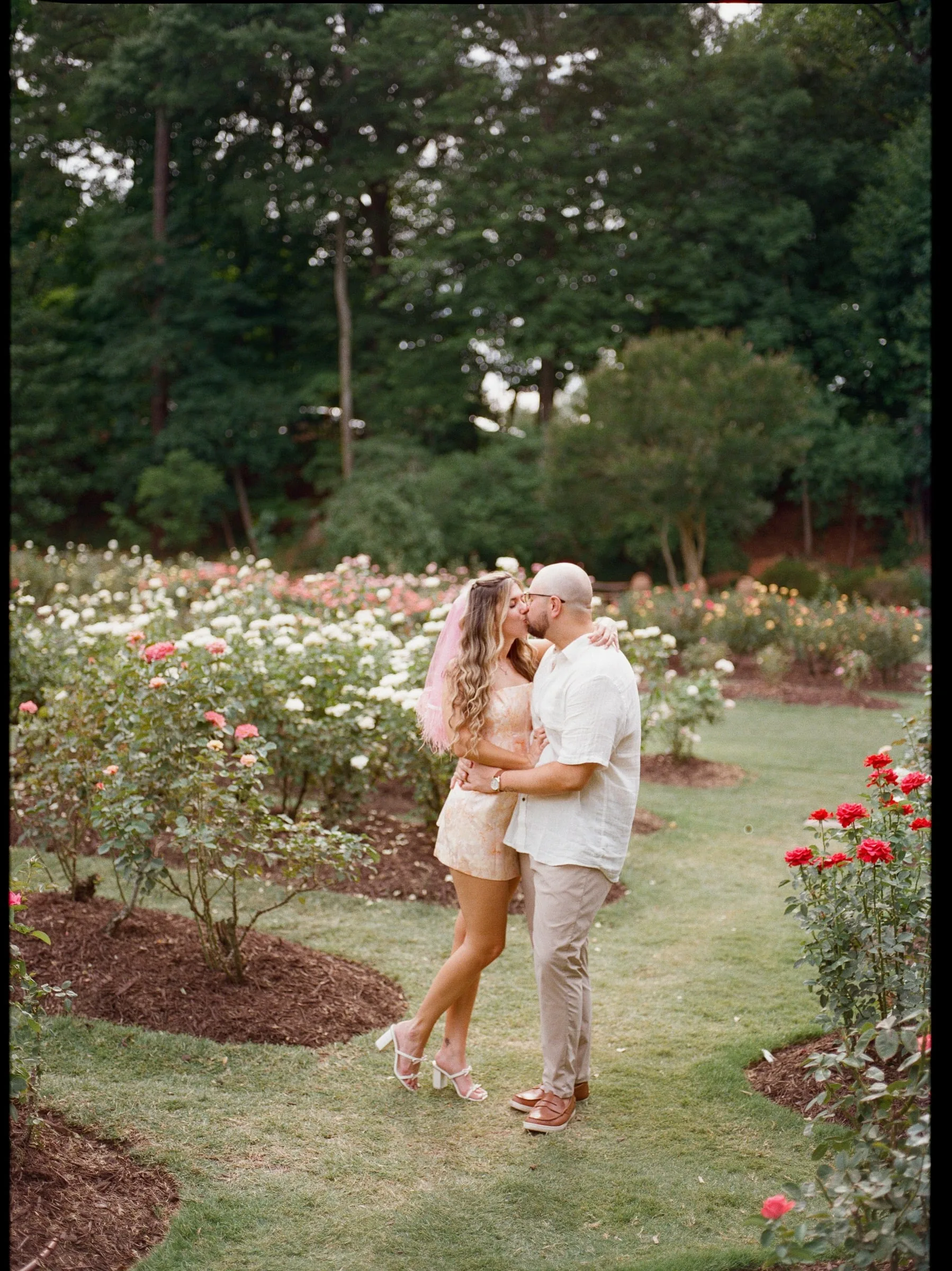 Nicole and Ian kissing on the garden path