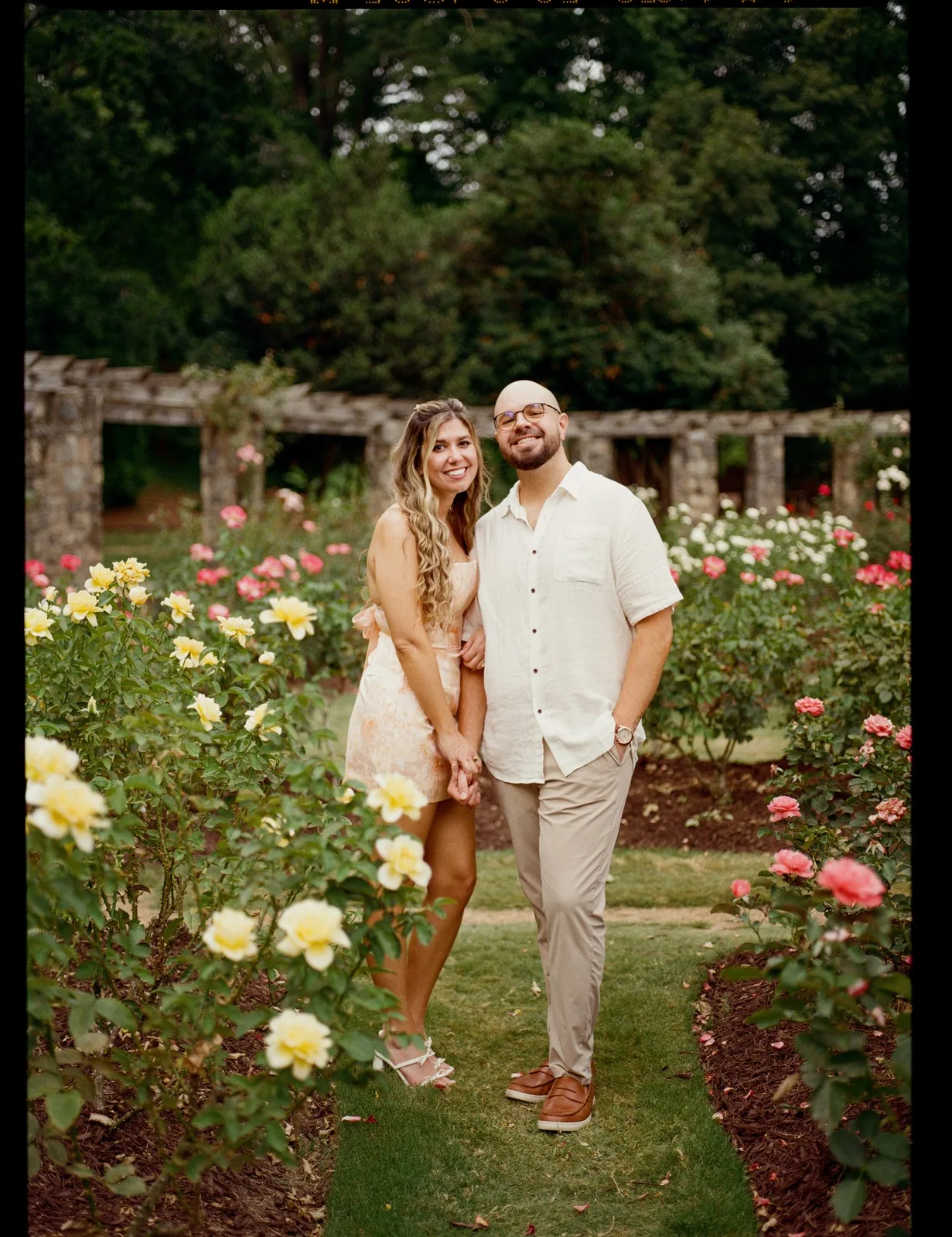 Nicole and Ian standing together in the rose garden