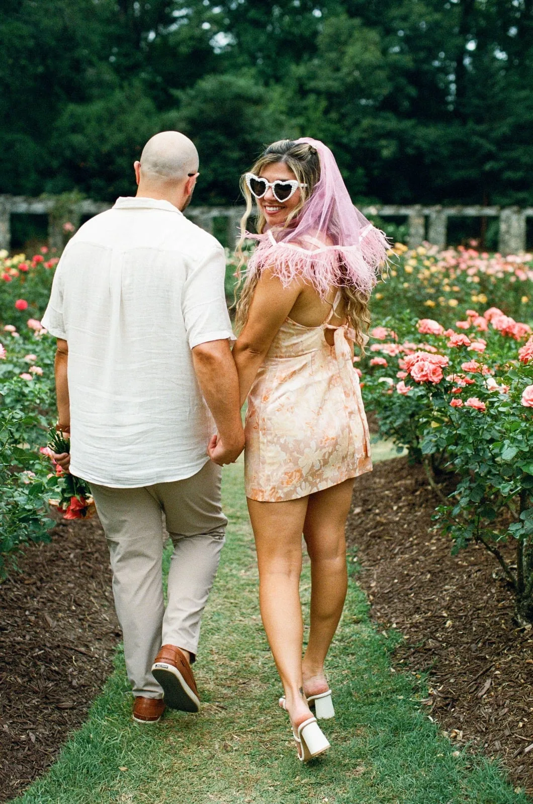 Nicole and Ian walking away down the garden path, Nicole looking back